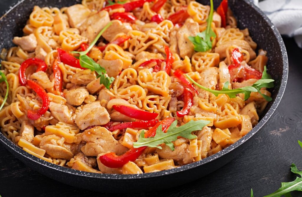 Chicken Vienna spaghetti garnished with pepper and arugula in a pan | Interchick whole chicken capon recipes